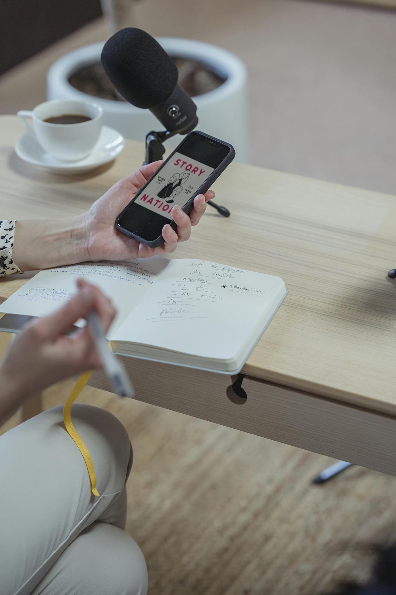 Crop unrecognizable woman using smartphone and writing in diary