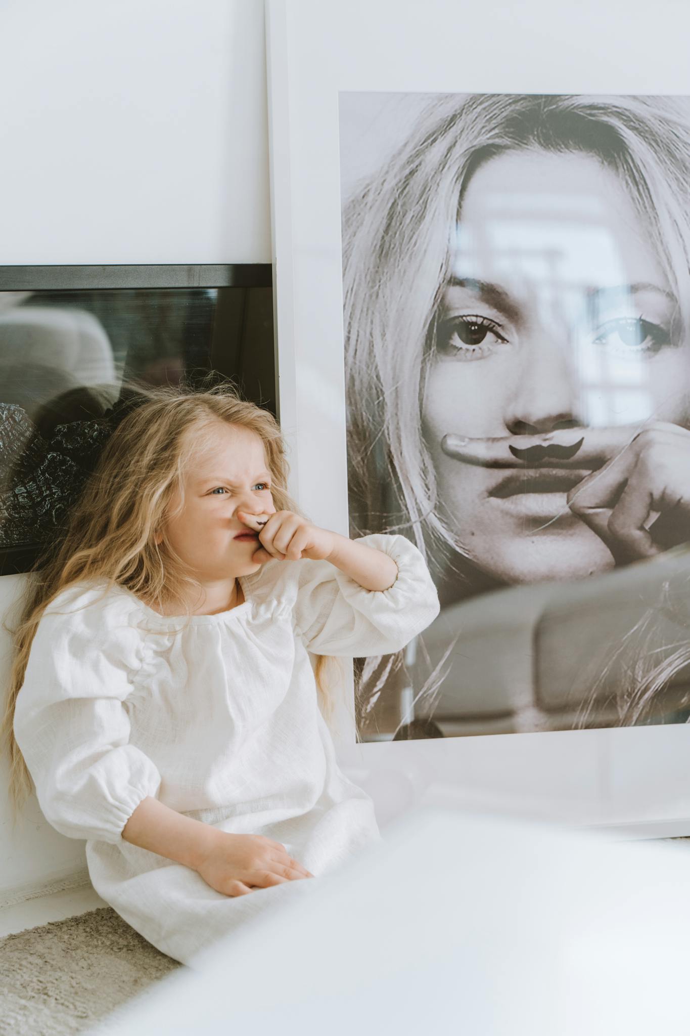 Girl Mimicking the Photo of a Woman in the Picture Frame